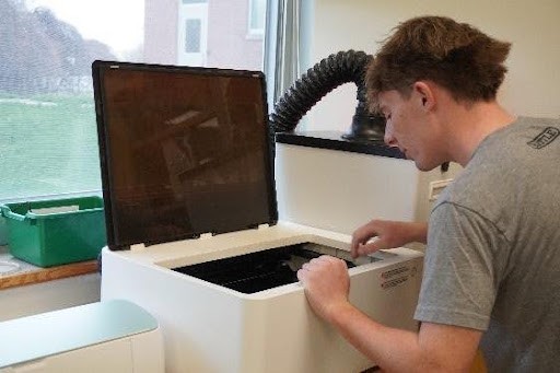 Image of student using a laser cutter/engraver