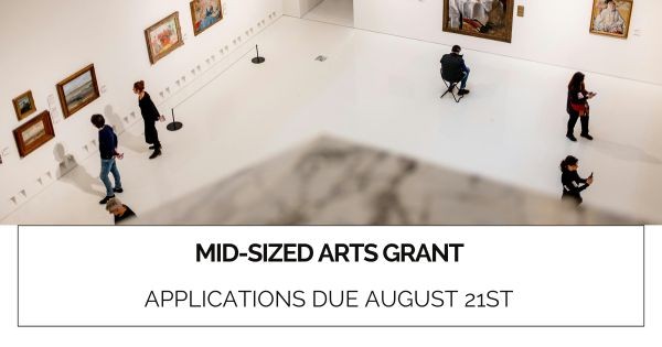 Graphic comprised of a photo of people looking at artwork in a museum with white floors and walls and text that says "Mid-Sized Arts Grant. Applications due August 21st"