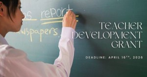 Image of someone writing on a chalkboard with text that says "Teacher Development Grant"