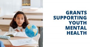 Graphic featuring a student sitting at a desk with a book and a globe. Text says "Grants SUpporting youth mental health"